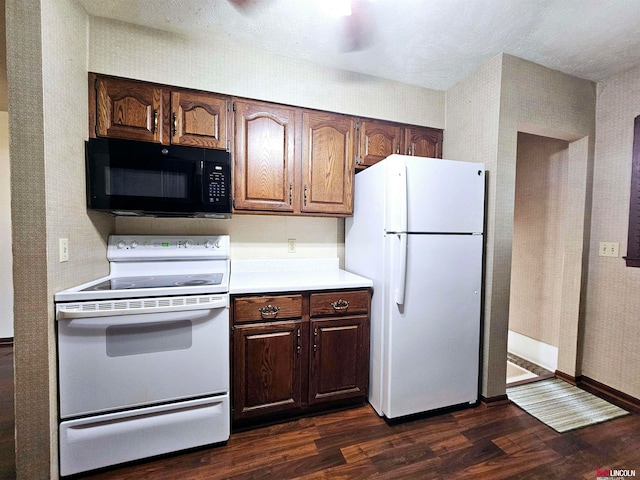 kitchen with white appliances, dark hardwood / wood-style floors, and a textured ceiling