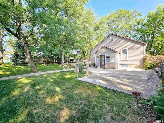 back of house with a yard and a patio