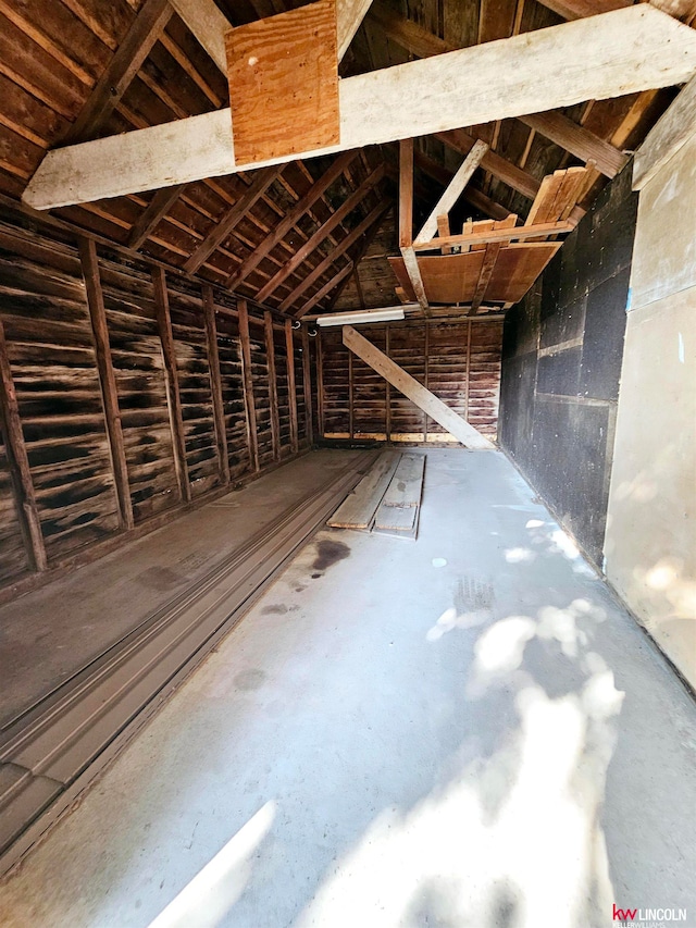 misc room with lofted ceiling and concrete flooring