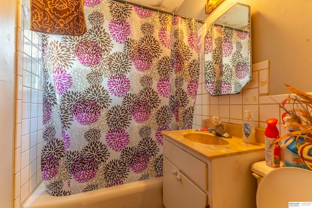 full bathroom featuring toilet, vanity, decorative backsplash, tile walls, and shower / tub combo