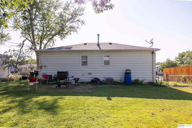 rear view of house featuring a yard