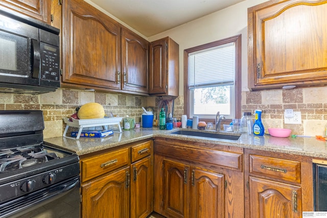 kitchen with black appliances, beverage cooler, sink, and tasteful backsplash