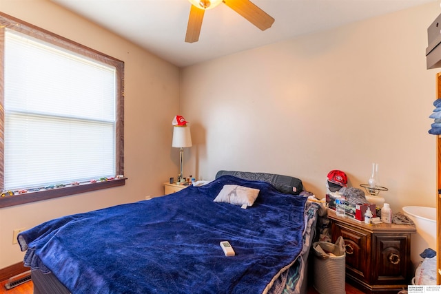 bedroom with ceiling fan, a wall unit AC, and hardwood / wood-style flooring