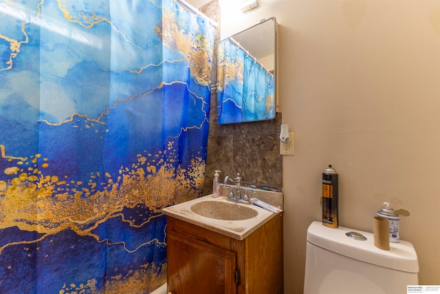 bathroom with a shower with shower curtain, toilet, and vanity