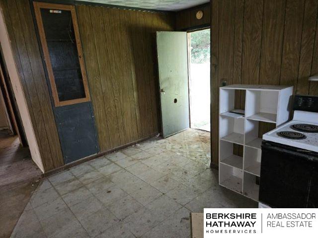 kitchen featuring wooden walls and white electric range oven