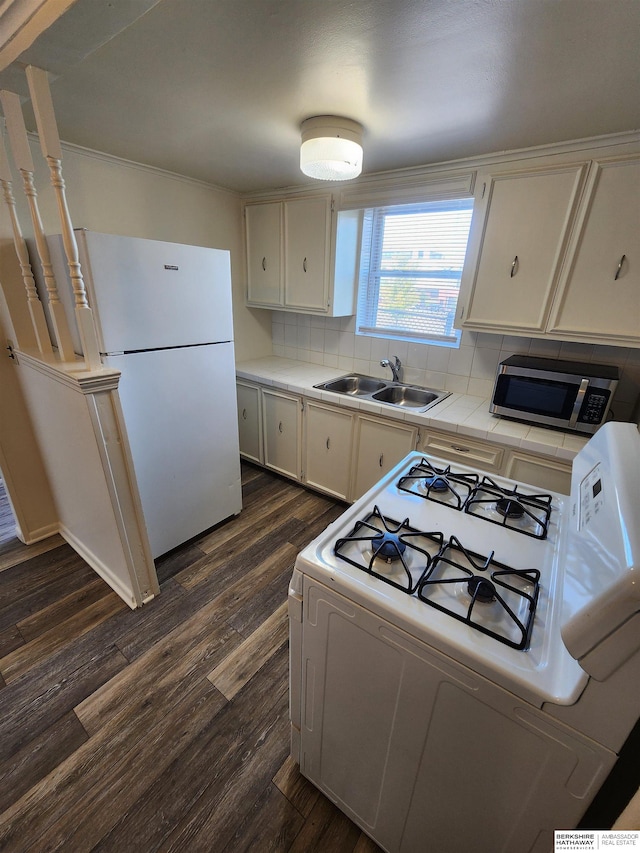 kitchen with white cabinets, sink, white appliances, dark hardwood / wood-style floors, and decorative backsplash