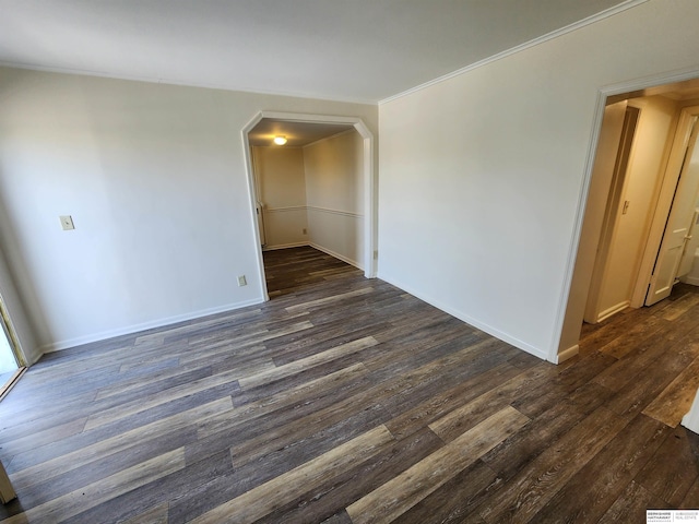 empty room with dark hardwood / wood-style floors and ornamental molding