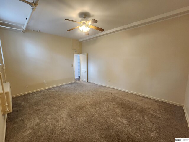 empty room featuring dark carpet and ceiling fan