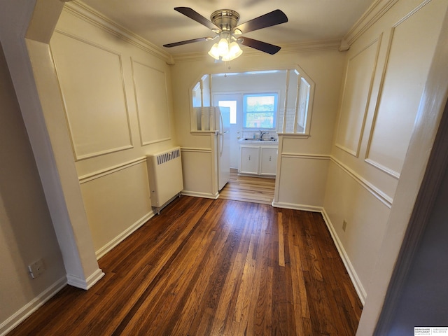 hall with ornamental molding, radiator, sink, and dark hardwood / wood-style flooring