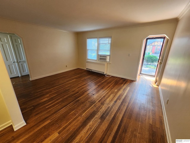 empty room with crown molding and dark hardwood / wood-style flooring