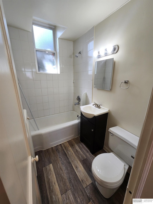 full bathroom featuring tiled shower / bath, vanity, toilet, and hardwood / wood-style flooring