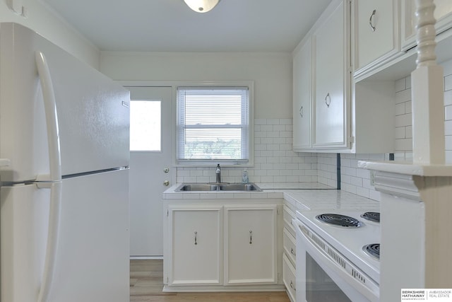 kitchen featuring light hardwood / wood-style floors, tasteful backsplash, sink, white cabinets, and white appliances