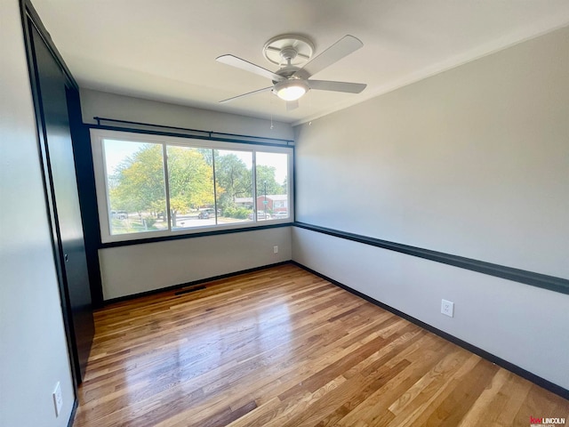 empty room with light wood-type flooring and ceiling fan