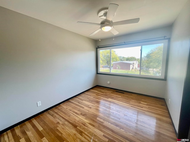 empty room with ceiling fan and light hardwood / wood-style floors