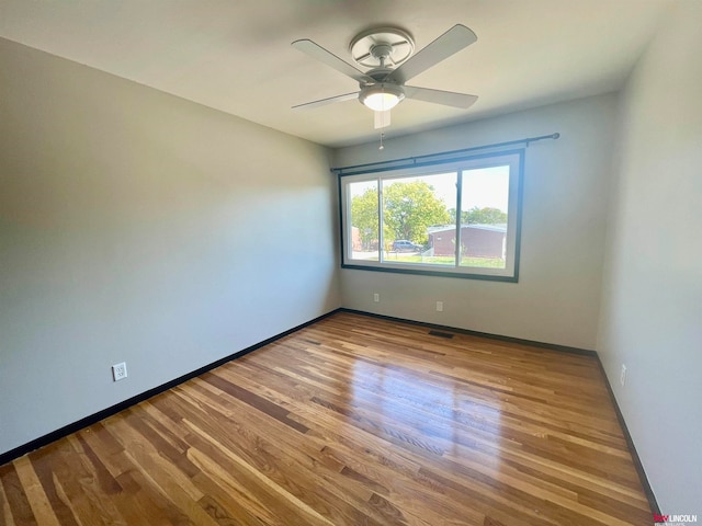 spare room with ceiling fan and wood-type flooring