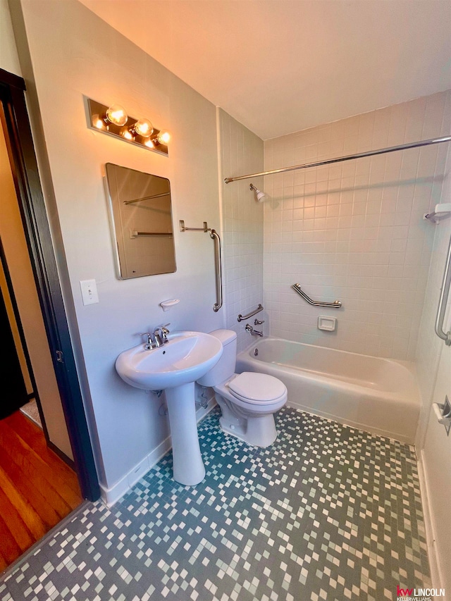 bathroom with wood-type flooring, toilet, and tiled shower / bath combo