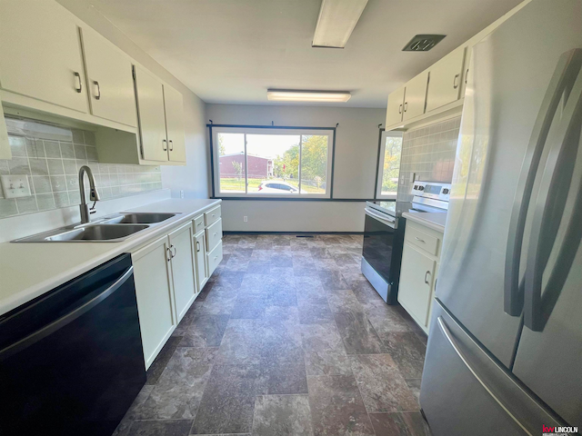 kitchen with appliances with stainless steel finishes, sink, and white cabinets