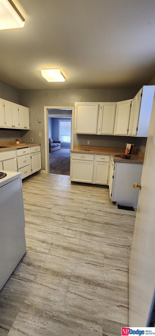 kitchen with white cabinets and white electric range