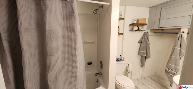 bathroom with hardwood / wood-style flooring, shower / tub combo, and toilet