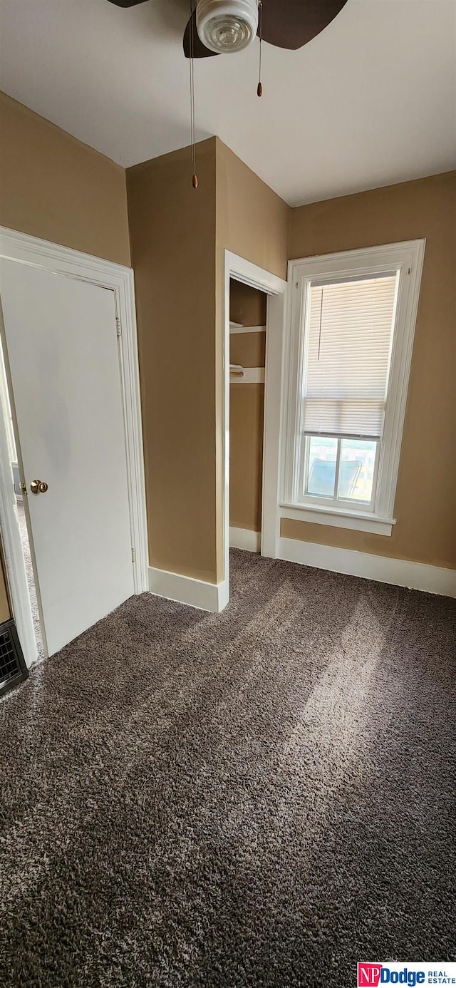 unfurnished bedroom with a closet, carpet, and ceiling fan