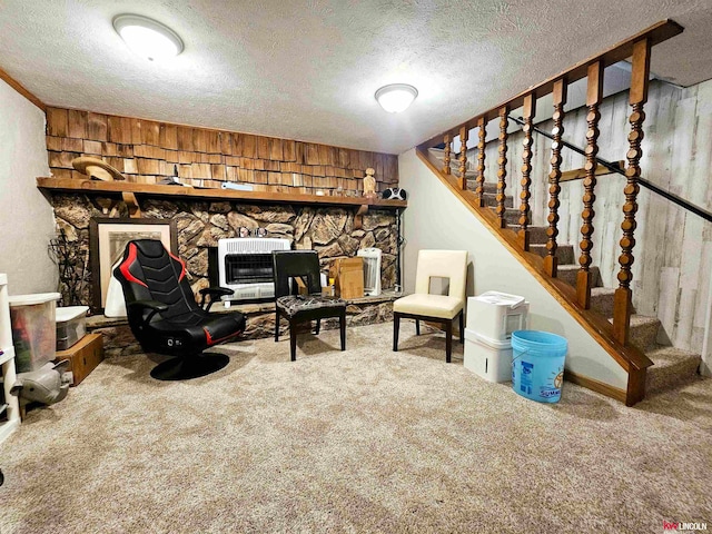 basement with a textured ceiling, a fireplace, wooden walls, and carpet