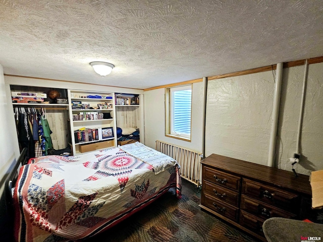 bedroom featuring dark carpet and a textured ceiling