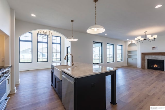 kitchen featuring decorative light fixtures, sink, a high end fireplace, and a wealth of natural light