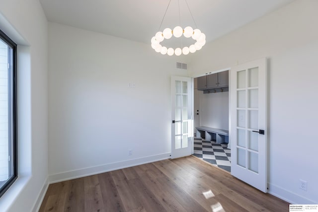 unfurnished room featuring french doors and hardwood / wood-style flooring