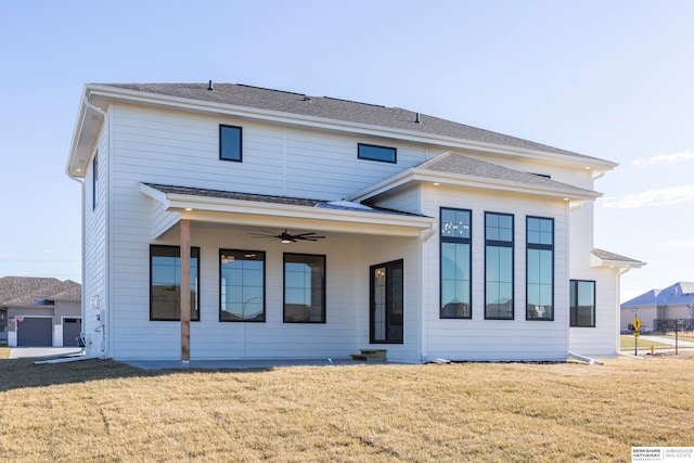 view of front of house with ceiling fan, a front yard, and a garage