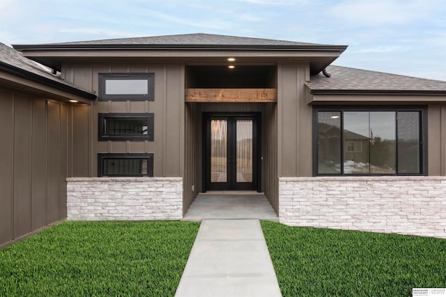 entrance to property featuring french doors and a yard