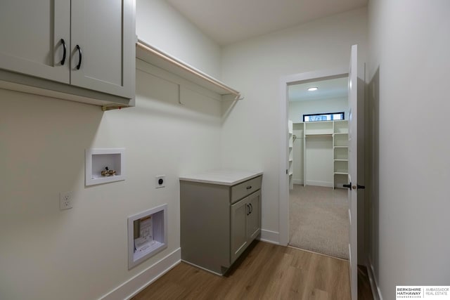 laundry area featuring hookup for a washing machine, cabinets, light wood-type flooring, and hookup for an electric dryer