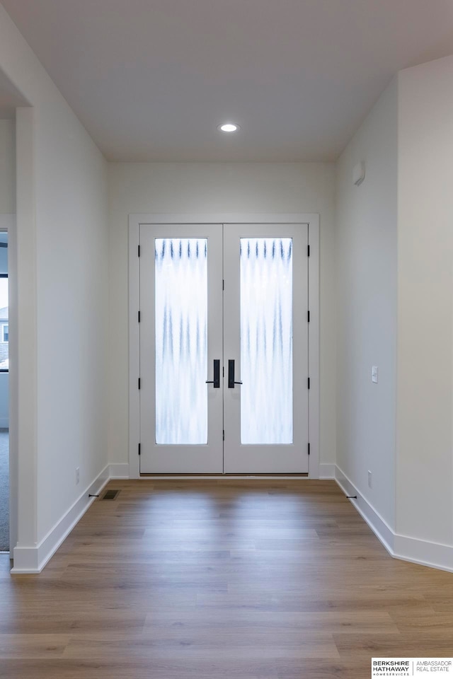 entryway featuring a wealth of natural light, light wood-type flooring, and french doors