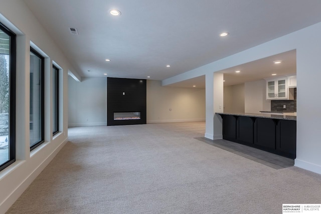 unfurnished living room featuring light colored carpet