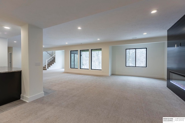 unfurnished living room with light carpet and a fireplace