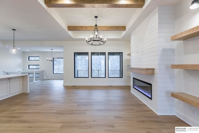 unfurnished living room featuring a notable chandelier, light hardwood / wood-style flooring, and beam ceiling