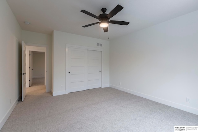 unfurnished bedroom featuring a closet, ceiling fan, and light colored carpet