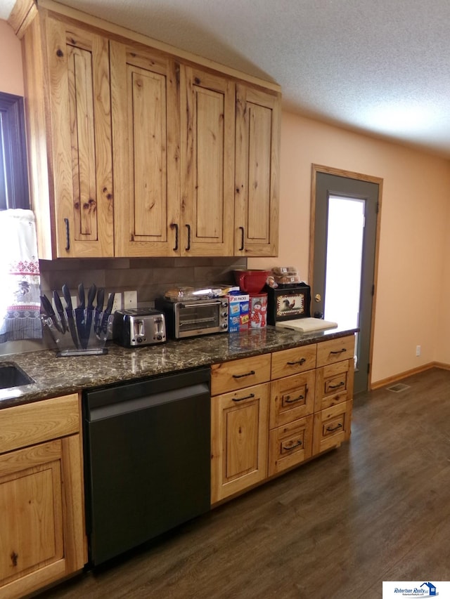 kitchen featuring a textured ceiling, stainless steel dishwasher, and dark hardwood / wood-style floors