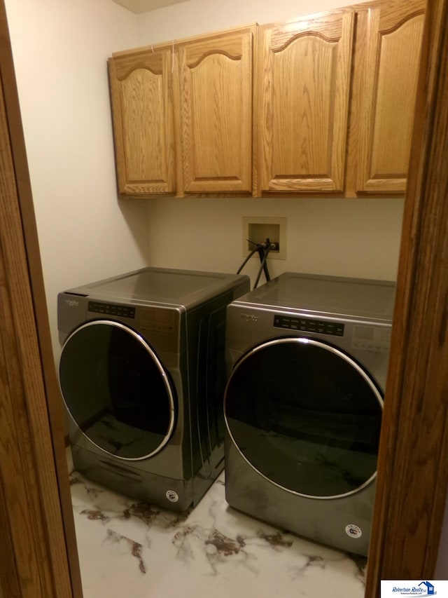 laundry area with washer and dryer and cabinets