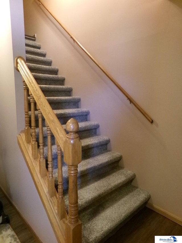 staircase with hardwood / wood-style floors