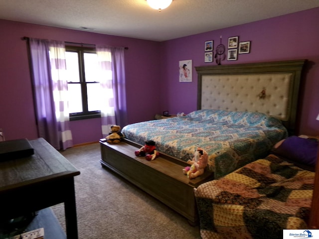 bedroom featuring a textured ceiling and light colored carpet