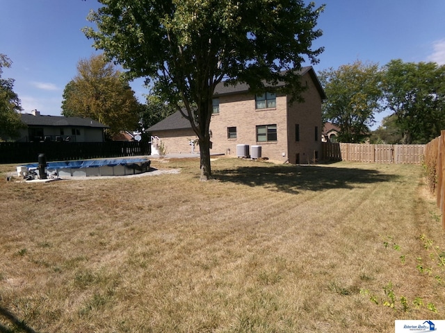 view of yard featuring central AC unit and a covered pool