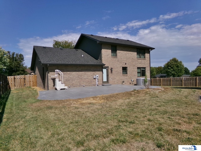 rear view of house featuring a lawn, a patio area, and central air condition unit