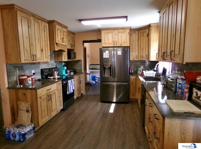 kitchen featuring stainless steel fridge, dark wood-type flooring, a textured ceiling, sink, and electric range