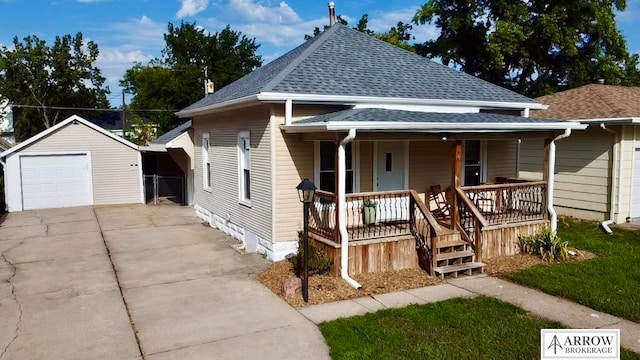 bungalow-style house with a garage, an outdoor structure, and a porch