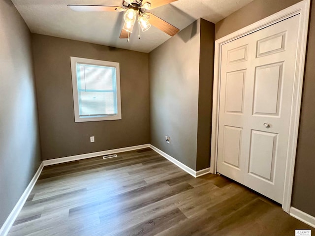 unfurnished bedroom with ceiling fan, a closet, and hardwood / wood-style floors