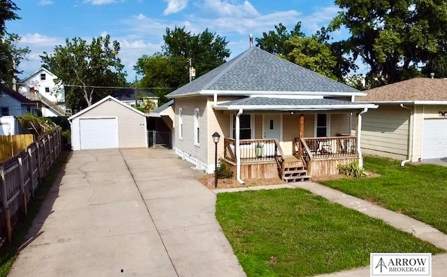 bungalow-style house featuring a front yard, a garage, an outdoor structure, and covered porch