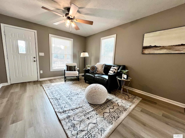 interior space with a textured ceiling, a healthy amount of sunlight, ceiling fan, and hardwood / wood-style flooring