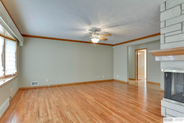 unfurnished living room featuring light wood-type flooring, crown molding, ceiling fan, and a multi sided fireplace