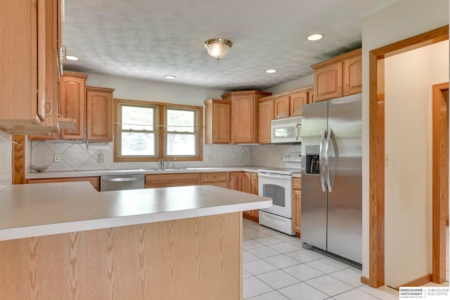 kitchen with appliances with stainless steel finishes, kitchen peninsula, light tile patterned floors, and backsplash