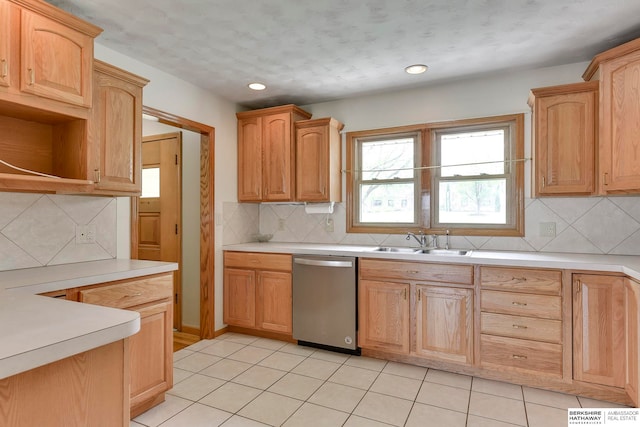 kitchen with light brown cabinets, light tile patterned floors, sink, stainless steel dishwasher, and decorative backsplash